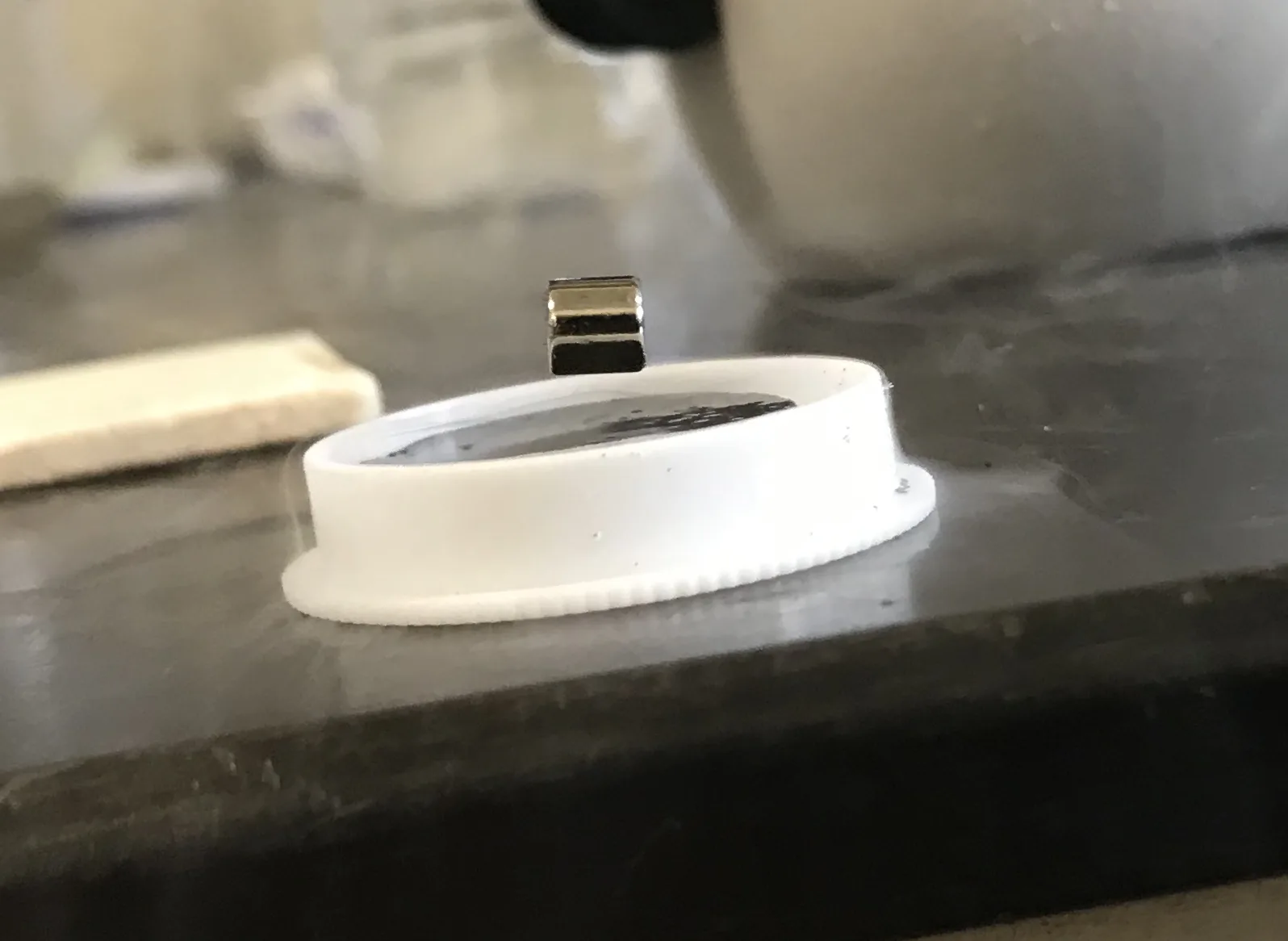 Floating magnet above lid.